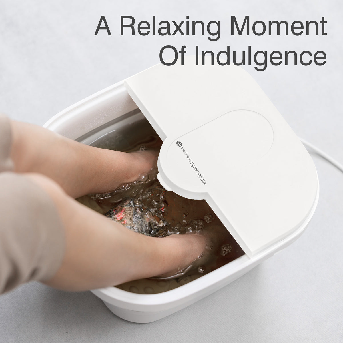 Another close-up of a person soaking their feet in the Foldaway Foot Spa Bath, with the bubbling water visible around their feet. The spa is designed to offer the best foot spa experience, combining heat, hydro-jets, and massage rollers for ultimate relaxation.