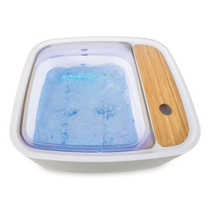 Scandinavian jacuzzi foot spa with blue spa lighting illuminated and filled with bubbling water 