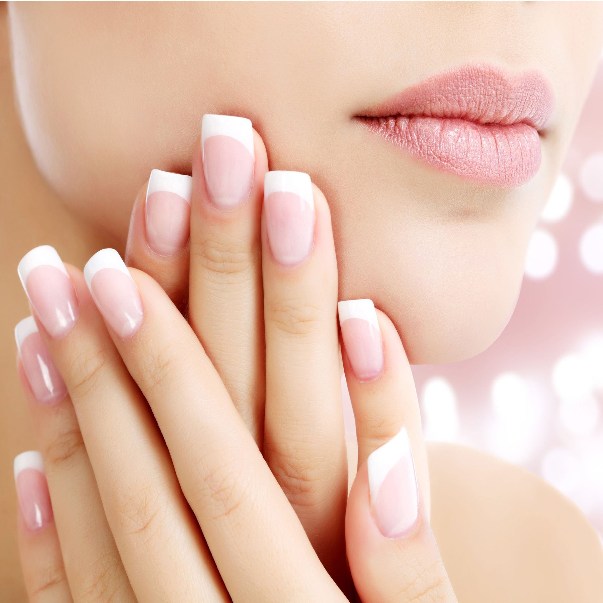 close up of ladies hands on face showing perfect french gel manicure nails 