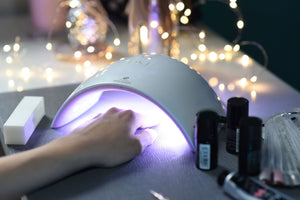 Salon Pro UV & LED Lamp in salon setting with ladies hand under showing blue UV light curing nails