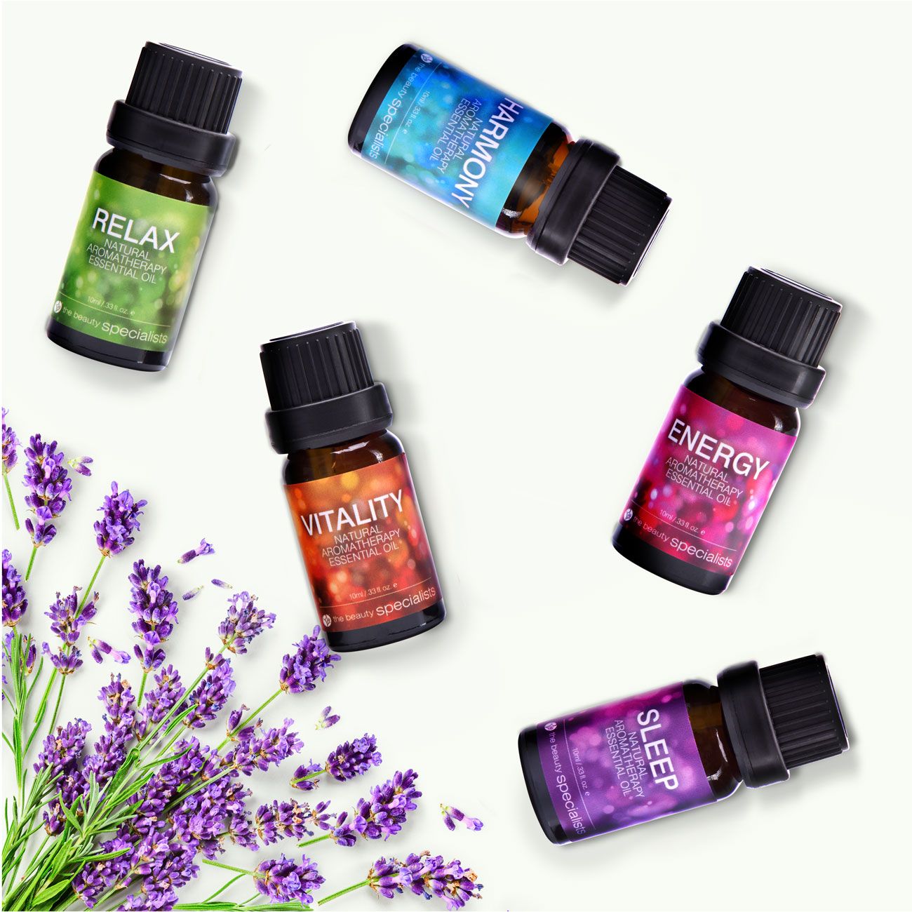rio wellbeing collection aromatherapy oils 5 10ml bottles relax harmony vitality energy and sleep scattered on a white surface with decorative sprigs of lavender in bottom left corner