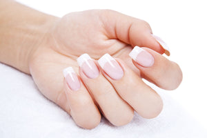 ladies hand laid on towel with french manicure gel nail extension 