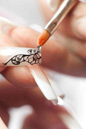 nail brush applying rhinestones to acrylic nails 