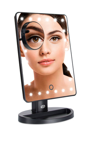 24 LED touch dimmable make up mirror with LED light illuminated and showing reflection of ladys face applying mascara with compact mirror attached displaying a 10x magnified reflection of ladys eye 