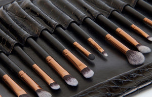 close up of small eye shadow brushes laid in luxury synthetic leather travel pouch 